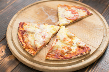 Slices of pizza on wooden background.