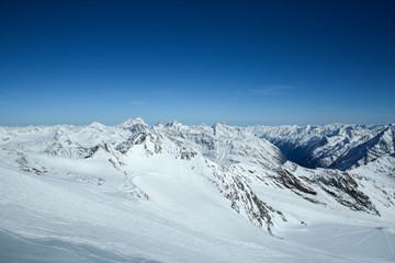 Fototapeta na wymiar Winter landscape - Panorama of the ski resort with ski slopes. Alps. Austria. Pitztaler Gletscher. Wildspitzbahn