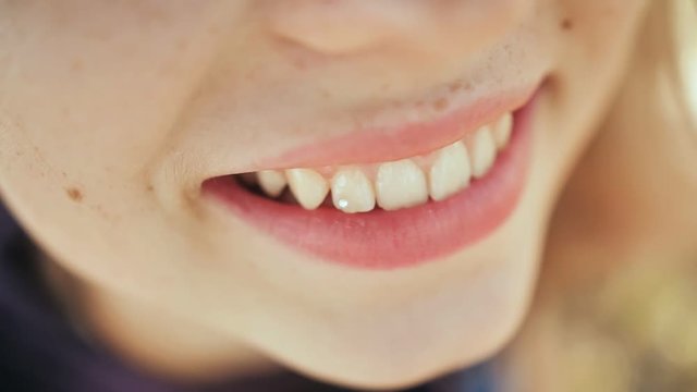 Young girl smiling with a diamond on a tooth. Skyce on the teeth. Dental diamond piercing.