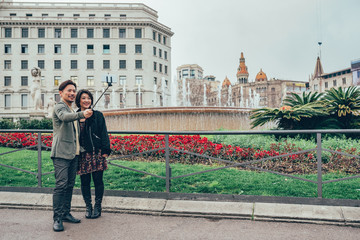 Fototapeta premium Asian tourist couple taking a selfie on the mobile phone