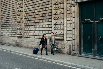 Asian happy tourist couple walking with suitcase