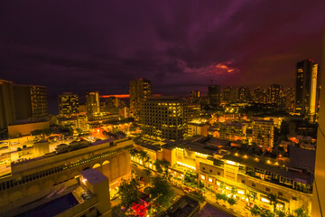 Fototapeta na wymiar Night lights of Waikiki cityscape in Oahu island Hawaii, United States. Dark sky with moving clouds and stars. City night lights and nightlife concept.