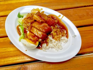 barbuced crispy pork in red sauce with rice - One of the most popular menu in this era of Thailand. Let's look at the hot rice, crispy pork with crispy salty red sauce.