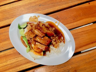 barbuced crispy pork in red sauce with rice - One of the most popular menu in this era of Thailand. Let's look at the hot rice, crispy pork with crispy salty red sauce.