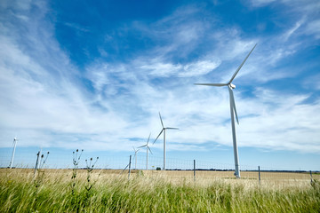 Industrial wind turbines in the middle of the fields. Renewable energy source. Ecological energy...