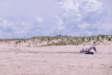 Isolated beach chair covered with beach towel on Rehoboth Beach, Delaware