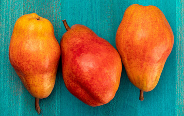 Delicious red pears On turquoise blue wooden background.