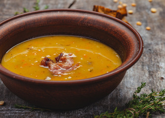 Pumpkin pea soup with bacon on wooden background. Close up