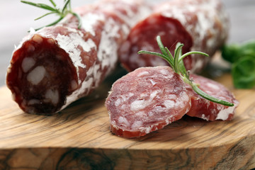 thinly sliced salami on a wooden texture on the background.