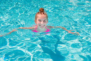 Teen girl in swimming pool squinting her eyes