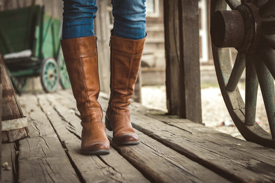 Walking on wooden floor with leather boots on old retro ranch. 
