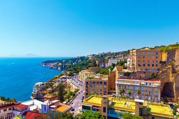 Fototapeta na wymiar View of the coast of Naples with clear blue sky. Houses on the shore of the Gulf of Naples. Italy, Europe.