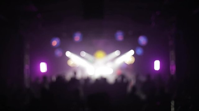People dance in a club in blur . Back view
