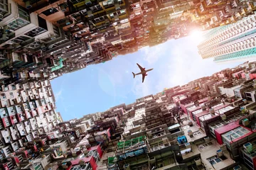 Fototapeten Flugzeug fliegt über überfüllte Häuser in Quarry Bay, Hong Kong © ronniechua