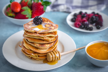 Fluffy and delicate pancakes with honey and berries.