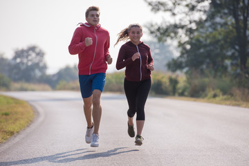Fototapeta premium young couple jogging along a country road