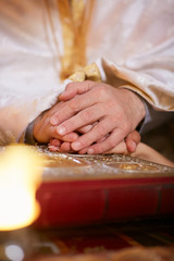 Bride and groom hold their hands on the Bible during engagement ceremony in church