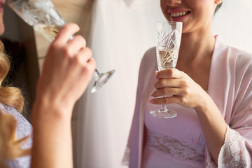 Bride and bridesmaids drink champagne preparing in the morning