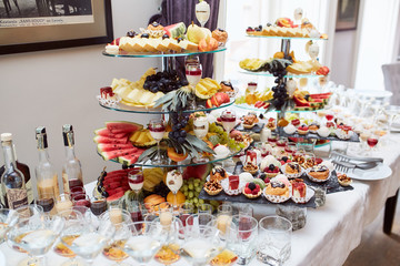 Wedding candy bar. Dishes with delicious sweets, cookies and chocolate cakes stand on the dinner table