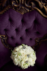 Little white wedding bouquet stands on violet chair