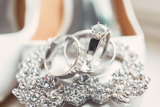 Classy silver wedding rings made of white gold lie on the crystal bracelet