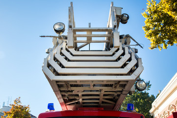 Fire truck ladder in folded state close-up against a blue sky.