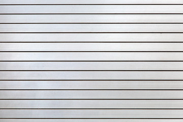 horizontal iron roller shutters of gray color close-up, metal gate texture.