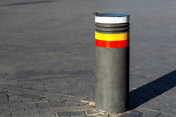 Retractable bollards on a background of gray paving slabs on a sunny day on an empty street nobody.