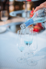 pouring white wine into glass, on white background