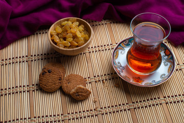 Homemade oatmeal cookies with a cup of tea on old wooden background, A cup of tea with raisin, a cup of tea with chocolate