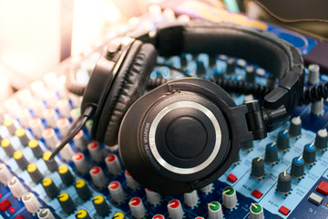 Fototapeta na wymiar Headphones on encoders of musical mixer