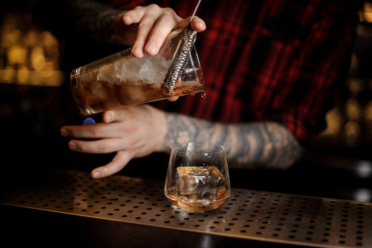 Bartender pourring an alcohol making a James Cook cocktail