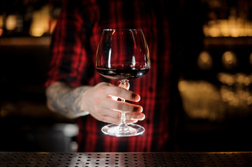 Professional bartender serving wine in a glass