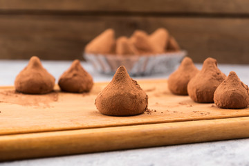 Chocolate candies in cocoa powder on a wooden Board.