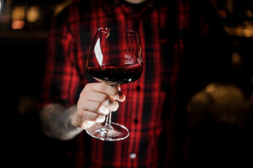 Man holding a burgunya glass filled with red wine