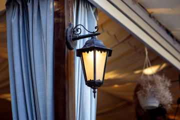 decorative lantern for gazebos and terraces wrought iron, sconces on a brown pillar with blue...