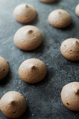 Fototapeta na wymiar chocolate meringue cookies on dark stone table, delicious dessert, top view, selective focus