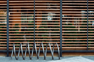 Bicycle parking for environmentally eco transport, on the background of the facade decorated with boards and greenery, nobody.