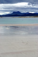 Mellon Udrigle, Scotland, UK: The bright blue waters off Mellon Udrigle Beach, on the West Coast of Scotland, under a cloudy sky.