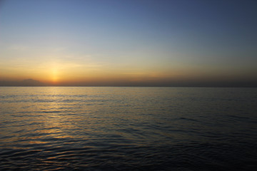 Naklejka na ściany i meble Calm and beautiful gold sunset at the ocean