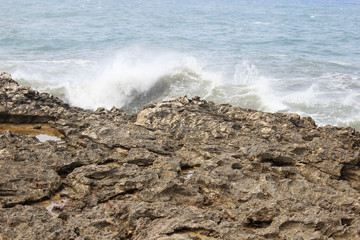 White waves on a blue ocean crashing on rock