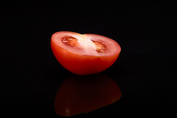 Fresh tomato on black background.