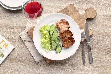 Plate with delicious meat and vegetables served on wooden table, flat lay