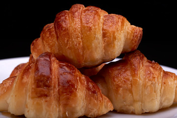 Tasty croissants with plate on black backgound