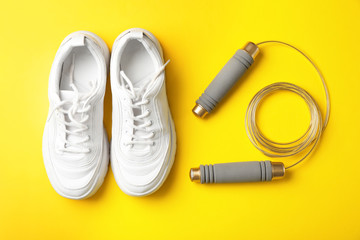 Jump rope and sneakers on color background. Healthy lifestyle