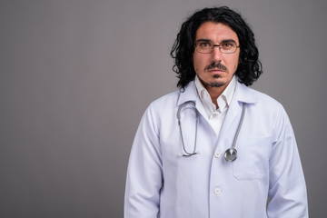 Handsome man doctor with mustache against gray background