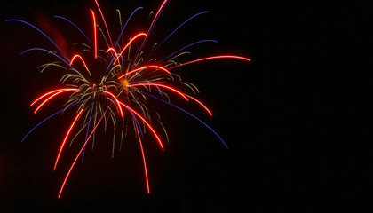 Red and blue arcs with gold arcs in center firework during the Fourth of July