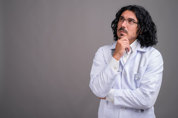 Handsome man doctor with mustache against gray background