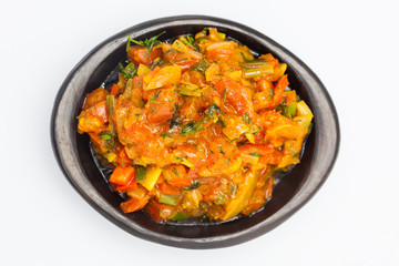 Traditional Colombian sauce called hogao served in a black ceramic dish isolated on white background