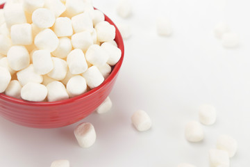 Fototapeta na wymiar Bowl Full of Mini White Marshmallows on a White Background